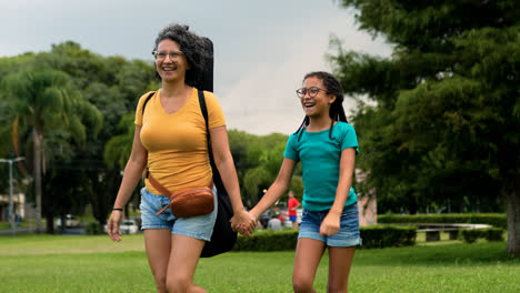 Mujer-Y-Niña-Caminando-Sobre-La-Hierba